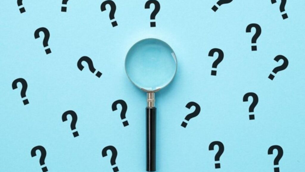 magnifying glass and question marks